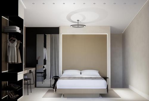 a bedroom with a white bed and a mirror at Nerion Hotel & Spa in Agia Marina Nea Kydonias