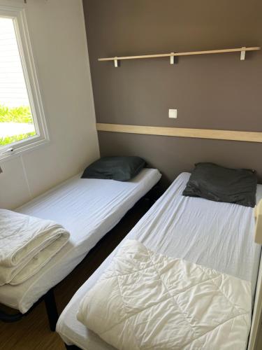 two twin beds in a room with a window at Mobilehome in Vias