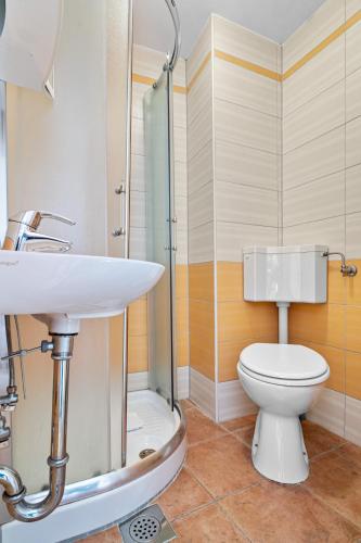 a bathroom with a toilet and a glass shower at Apartment old Town in Lovran