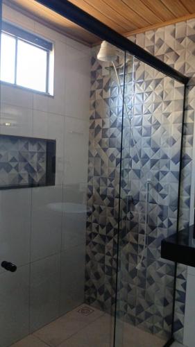 a shower with a glass door in a bathroom at Pousada Cocobeach Adventure - Miracema do Tocantins in Palmas