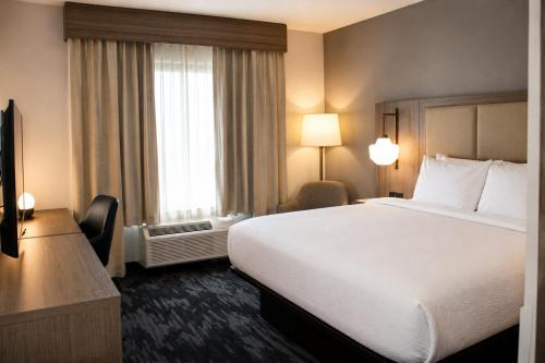 a hotel room with a large bed and a window at City Express by Marriott Lafayette in Lafayette