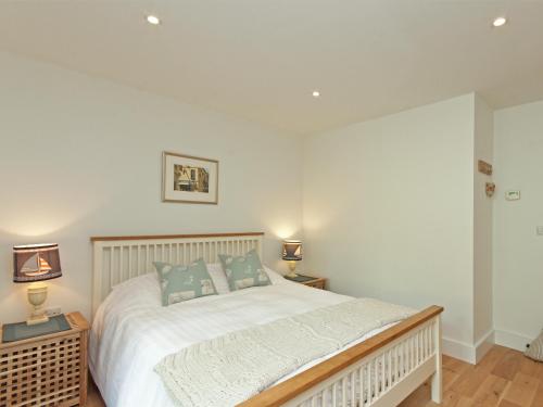 a bedroom with a large white bed with two lamps at Eddystone Row 2 in Salcombe