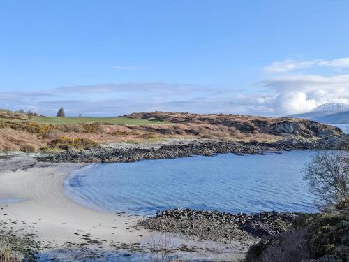 a body of water next to a sandy beach at Plover Apartment - Uk51129 in Carradale