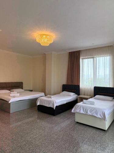 a room with two beds and a chandelier at Family Hotel in Batumi