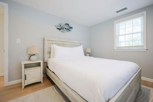 a white bedroom with a large bed and a window at Prime Weeks Still Available, Renovated, Beaches! in Yarmouth