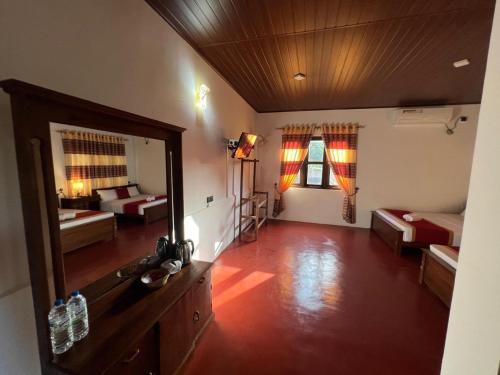a large room with two beds and a mirror at The Red Loft Mihinthale in Anuradhapura
