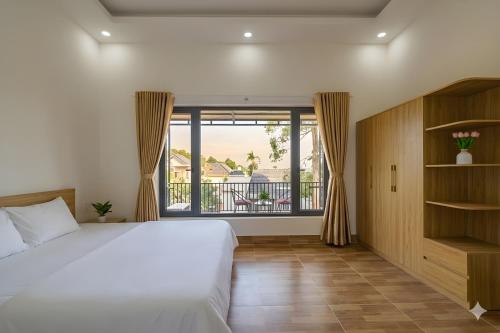 a bedroom with a large bed and a balcony at Golden Hill Villas Phu Quoc in Phú Quốc