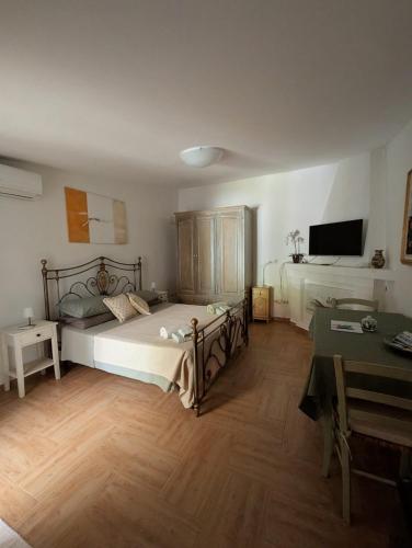 a bedroom with a bed and a desk and a television at La casa del glicine Marrubiu in Marrùbiu