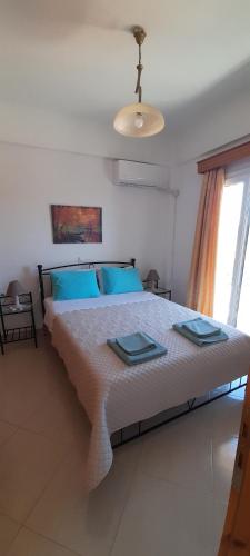 a bedroom with a large bed with blue pillows at Kate House in Agioi Apostoli