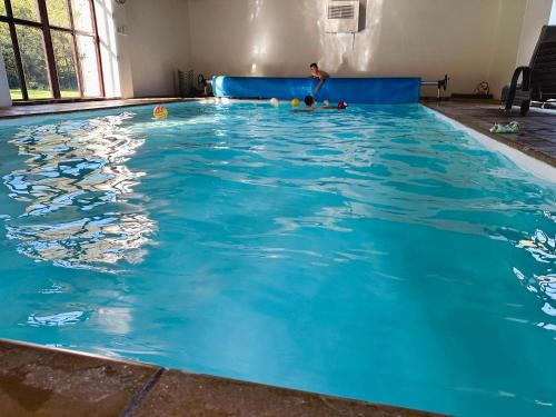 a swimming pool with a boy in the water at Lake Cottages at Cwm Chwefru in Llanafan-fawr
