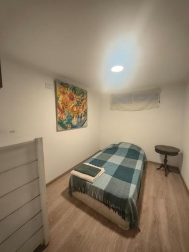a bedroom with a bed and a desk and a painting at Hospedaje La Trinidad in Junín