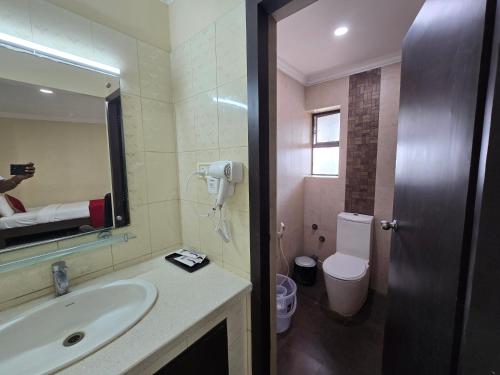 a person taking a picture of a bathroom with a sink at Hotel Ashok Residency, Porur in Chennai