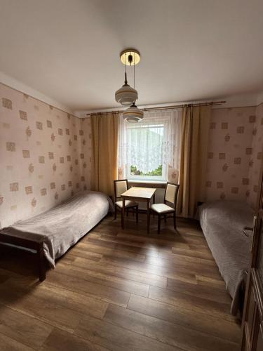 a room with two beds and a table and a window at Zakątek in Porąbka