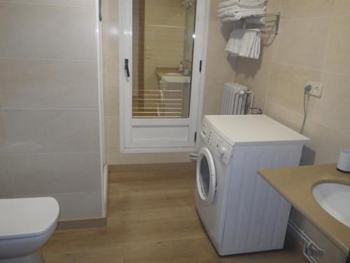a bathroom with a washing machine and a sink at Hotel Del Llac in Coll de Nargó
