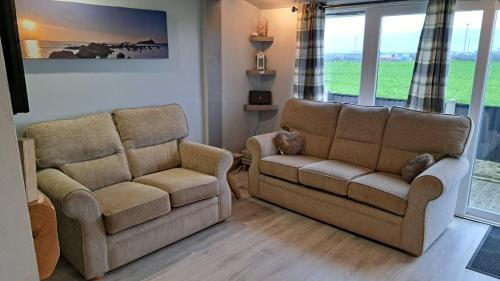 two chairs and a couch in a living room at Beach 100m - Sea View - Log Burner - Dogs Welcome in Bridlington