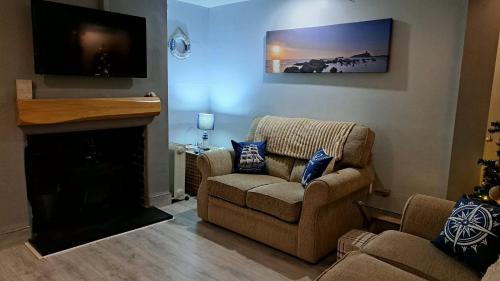 a living room with a couch and a fireplace at Beach 100m - Sea View - Log Burner - Dogs Welcome in Bridlington