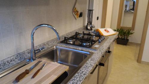 Appartamento Berlicche في Agliana: طاولة مطبخ مع حوض وموقد