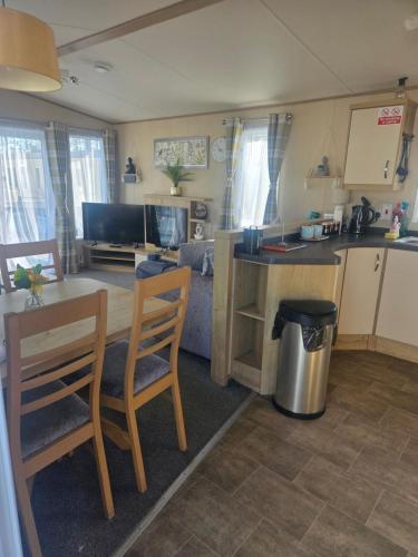 a kitchen and living room with a table and chairs at 50A ALDERLEY at Hoburne bashley in New Milton