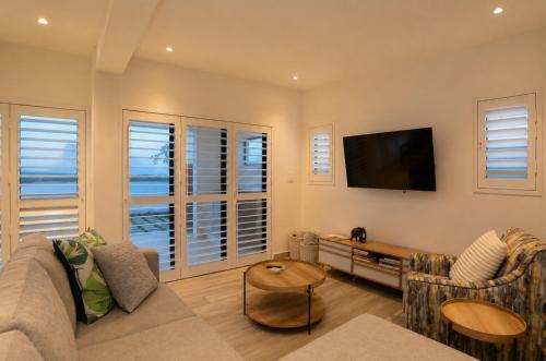 a living room with a couch and a flat screen tv at Yzer4You in Yzerfontein