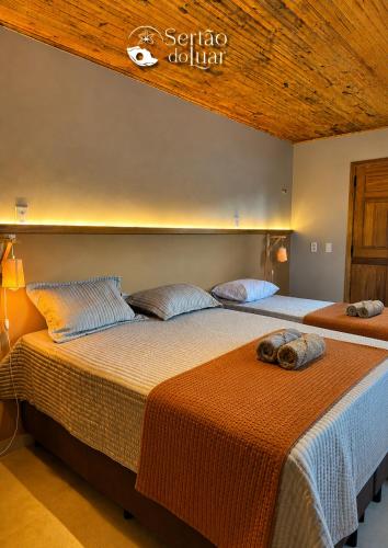 two beds in a hotel room with at Chalé Caroá in São Raimundo Nonato