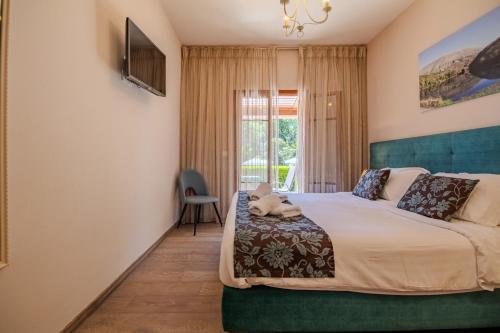 a bedroom with a bed and a window at Summer Nights Resort in Ipsos