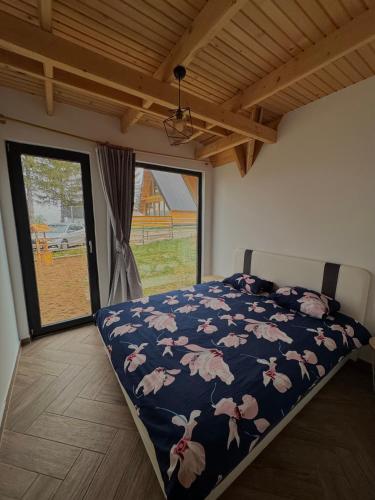 a bedroom with a bed with a blue blanket with pink birds at Vlasic Odmor - Villa Ajla in Vlasic
