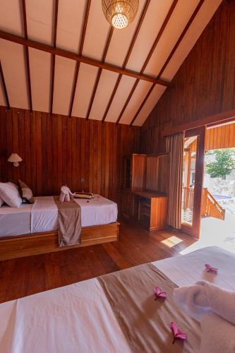 a bedroom with two beds with pink shoes on them at Two Sisters Villa with Pool - Sire in Tanjung
