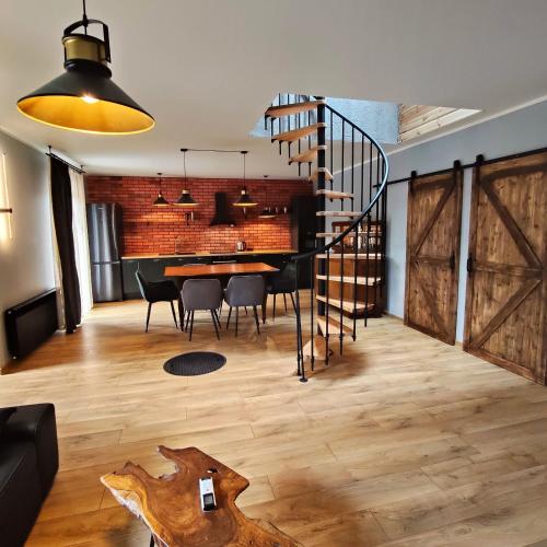 a dining room with a staircase and a table with chairs at LoftLove Lubianka in Starachowice