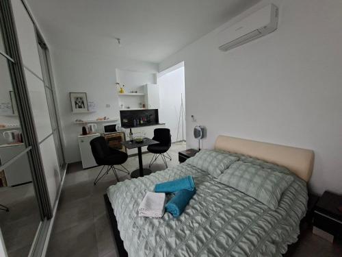 ein Schlafzimmer mit einem Bett und einem Schreibtisch mit Stühlen in der Unterkunft Cozy studio! in Paphos City