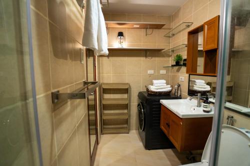 a small bathroom with a sink and a washing machine at The Mosaic Tower Luxury Boutique Studio,Pool and Gym Fast Wifi in Manila