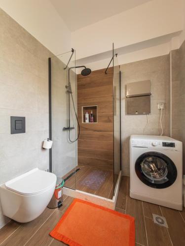 a bathroom with a toilet and a washing machine at Morpheas Apartment in Central Myrina in Myrina