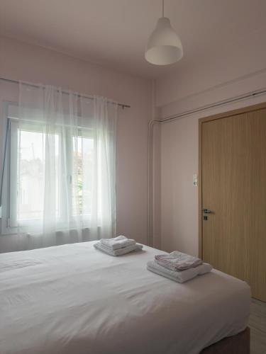 a bedroom with a large bed with two towels on it at Morpheas Apartment in Central Myrina in Myrina