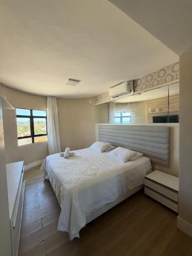 a bedroom with a large white bed and a window at Elegance Comfort Natal Beira mar Coberturas Vip in Natal