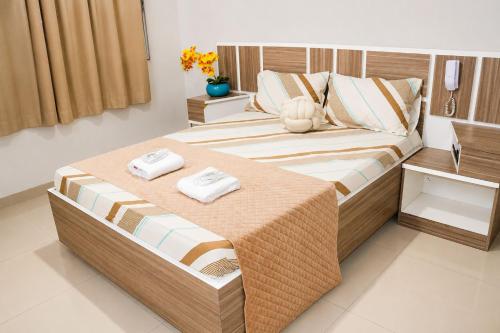 a bedroom with a bed with two towels on it at GM Hotel SP in Utinga