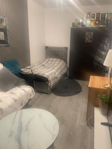 a living room with a bed and a table at Room Younis in Tilehurst