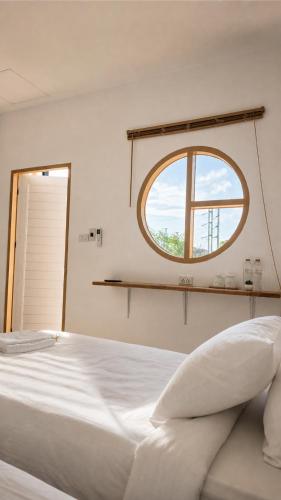 a bedroom with a white bed and a window at OneVillaResort in Ban Son Tap Tao