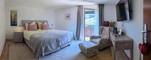 a bedroom with a bed and a chair and a window at Mitzi's Zauberblick in Landeck