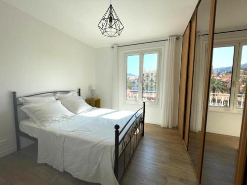 a bedroom with a bed and a large window at VERLAINE House in Menton