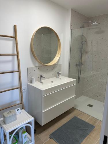 a bathroom with a sink and a shower with a mirror at Les palmiers Maxime in Sainte-Maxime