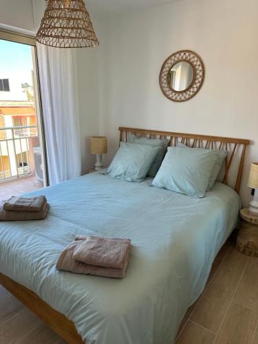 a bedroom with a large bed with towels on it at Les palmiers Maxime in Sainte-Maxime