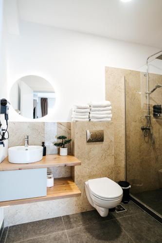 a bathroom with a toilet and a sink and a shower at Riverside ApartHotel by InnTime in Cluj-Napoca