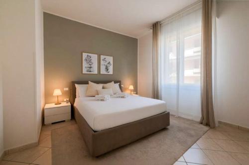 a bedroom with a large white bed and a window at Deluxe Flat Empoli GVARO in Empoli