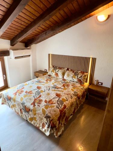 a bedroom with a bed with a floral bedspread at Belle vue des Alpes in Blavy