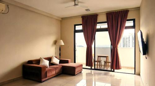 a living room with a couch and a large window at Bouncing Fun House in Medini in Iskandar Puteri