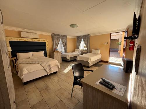 a hotel room with a bed and a desk and a room at Guesthouse 116 on McLean in Welkom