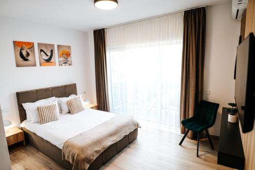 a bedroom with a bed and a large window at Riverside ApartHotel by InnTime in Cluj-Napoca