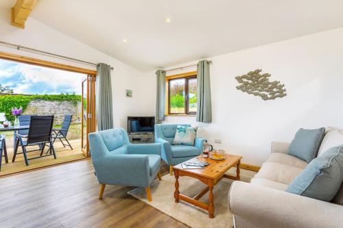 a living room with a couch and chairs and a table at L54 - Sunny Corner in Truro