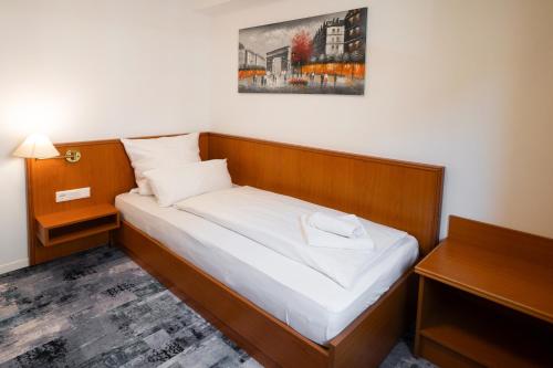 a bedroom with a bed with a wooden headboard at Hotel zur Post in Herne