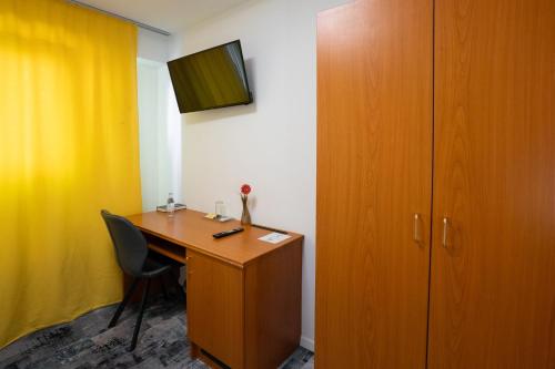 a room with a desk with a chair and a cabinet at Hotel zur Post in Herne