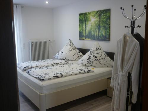 a bed with white sheets and pillows in a room at Haus Bernhardt in Langenargen